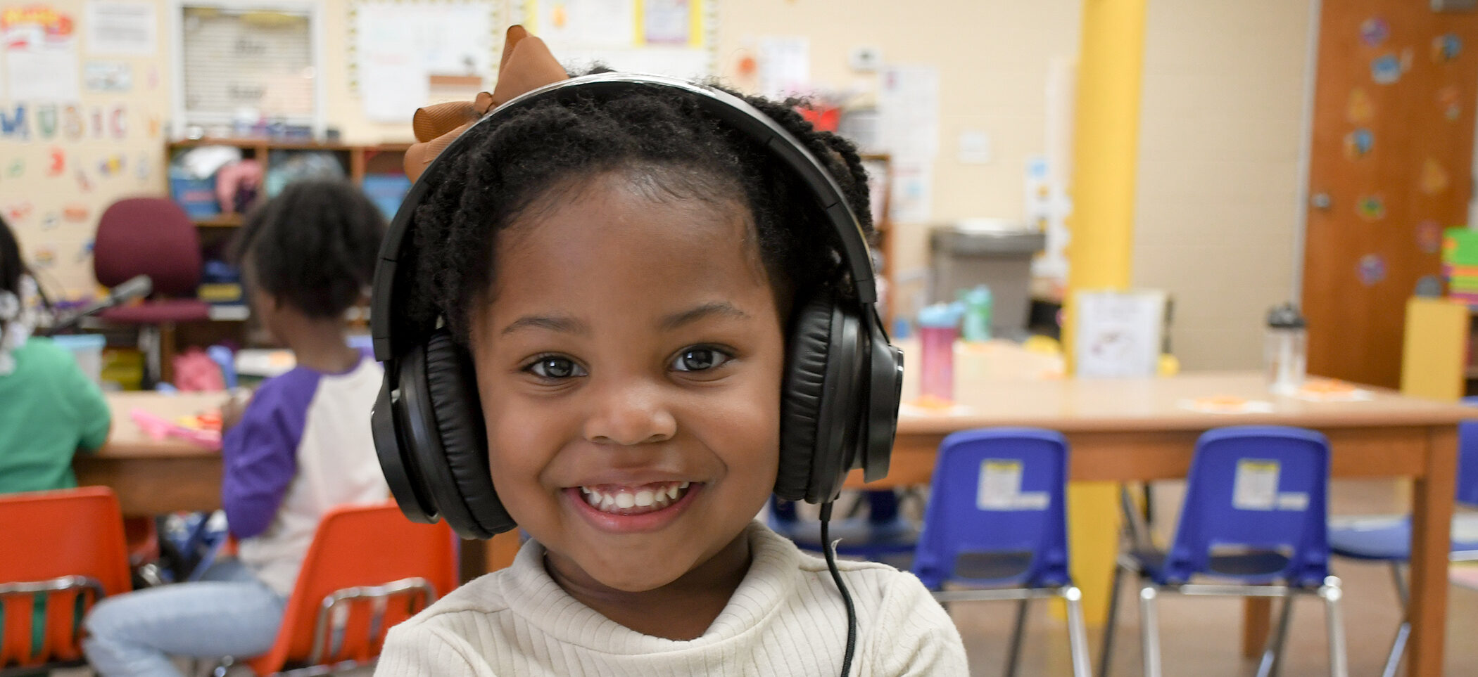little girl with headphones learning at daycare