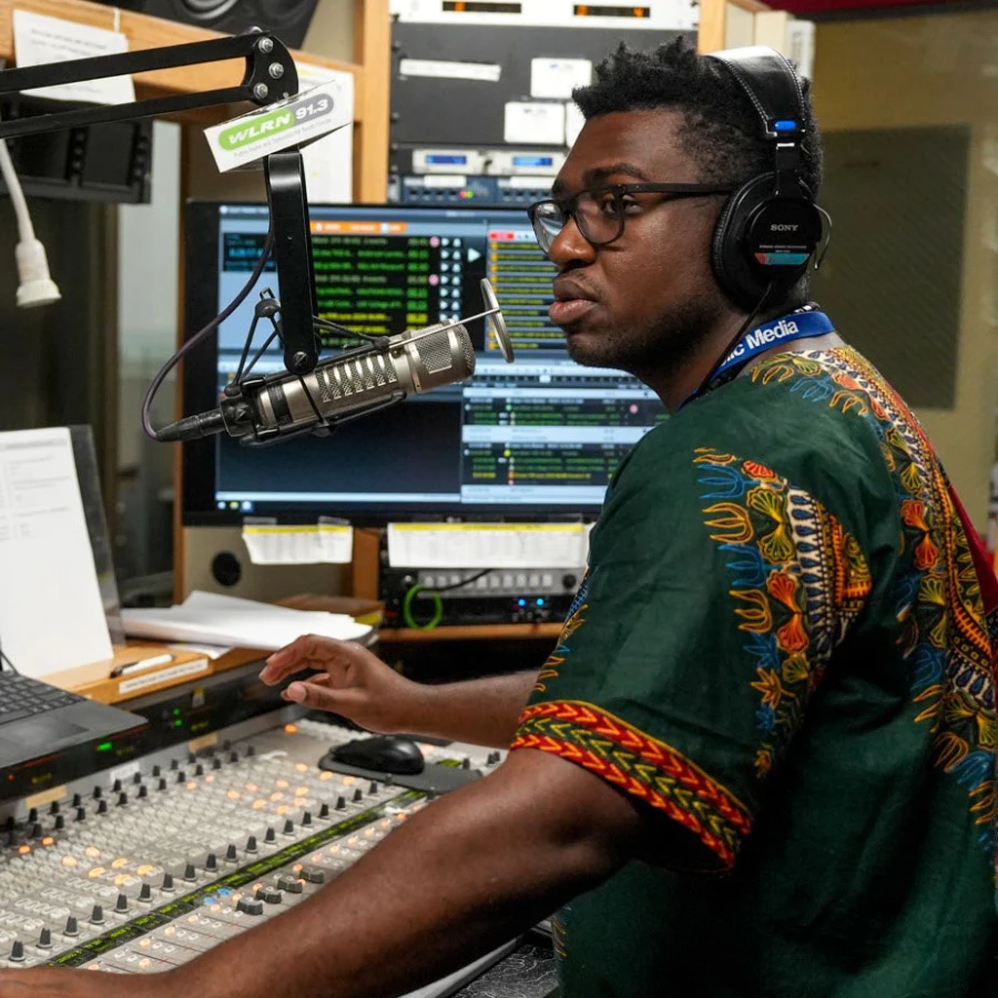 An audio engineer inside the booth for a local radio station