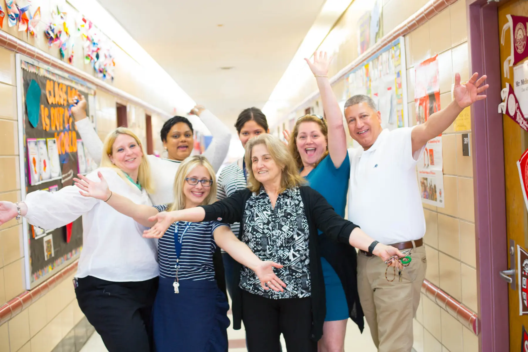 A group of professionals pose for a photo in a hallway