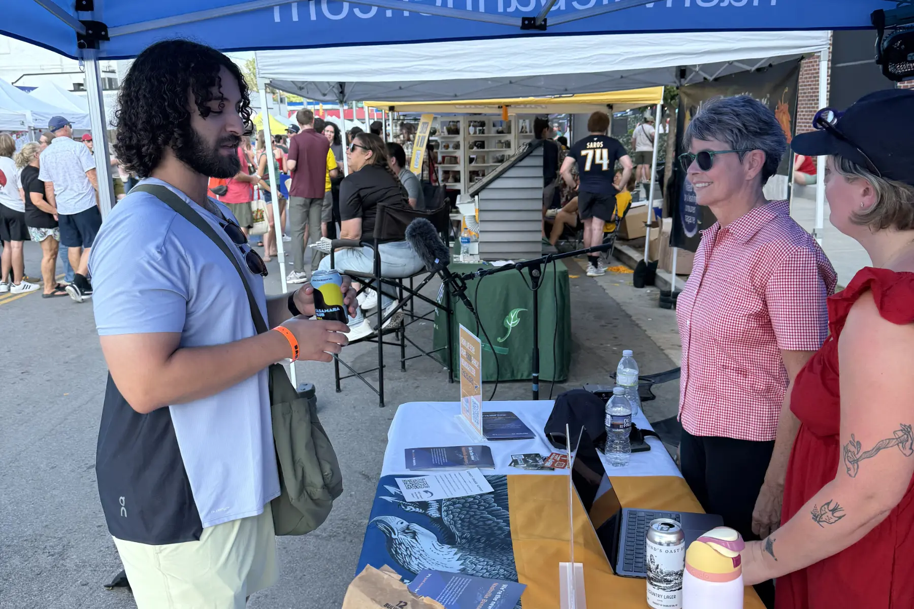 Two representatives from Nashville Banner talk with a community member at their fair booth.