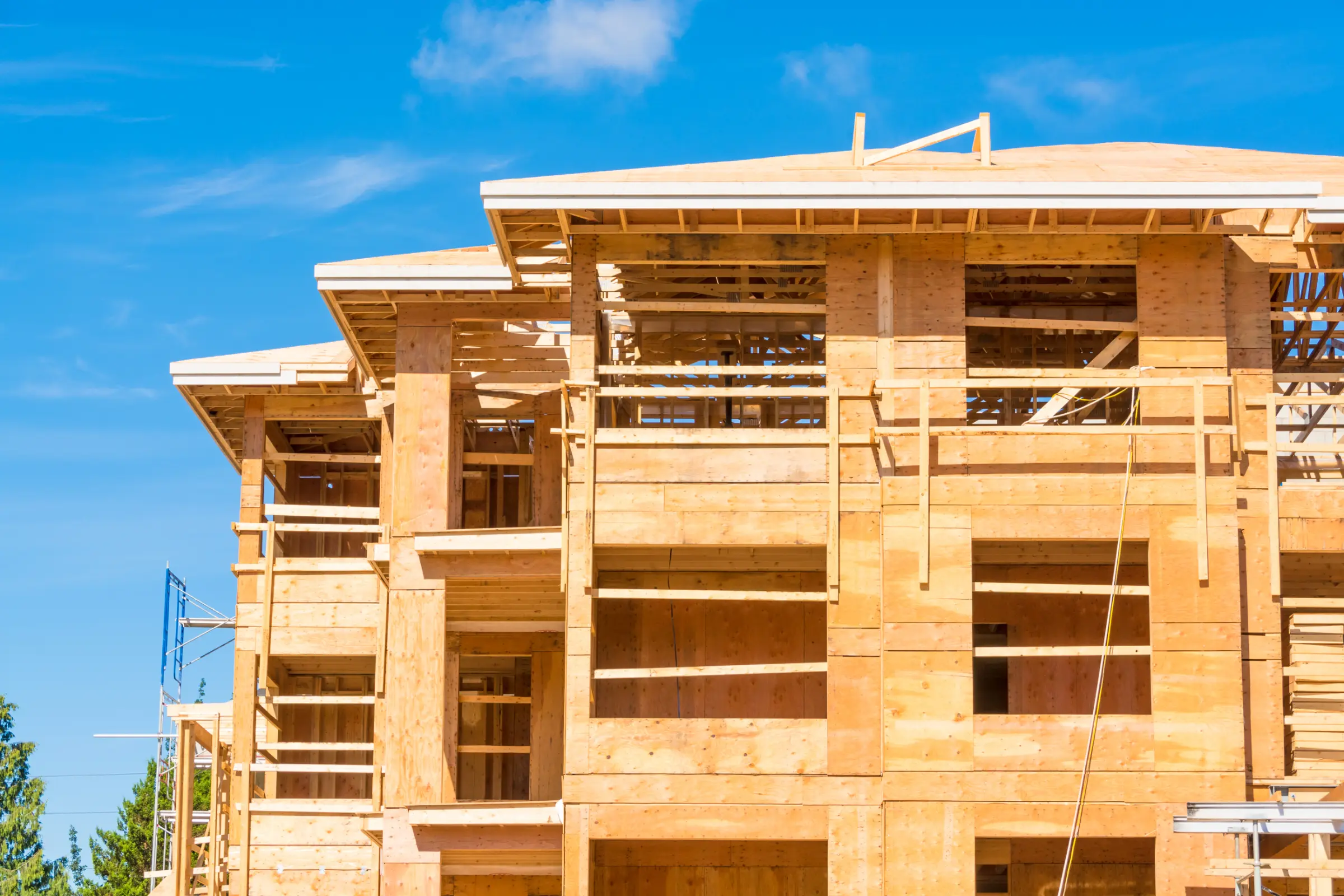 A multi-unit affordable housing project is shown in the middle of construction with the framing completed.