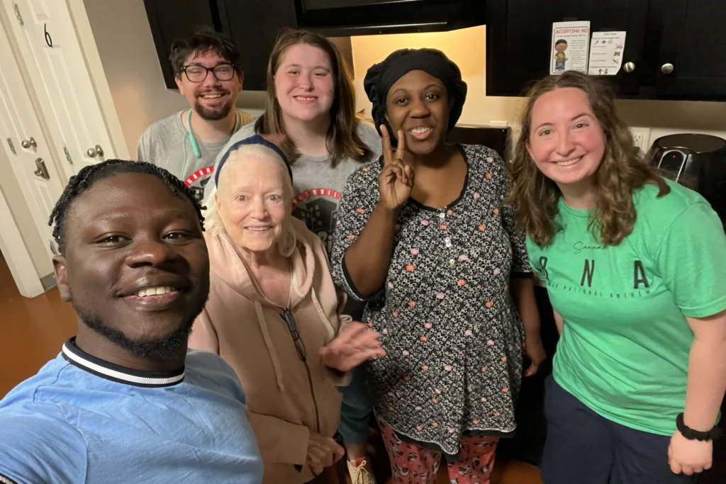Residents pose in the kitchen with Rosemary