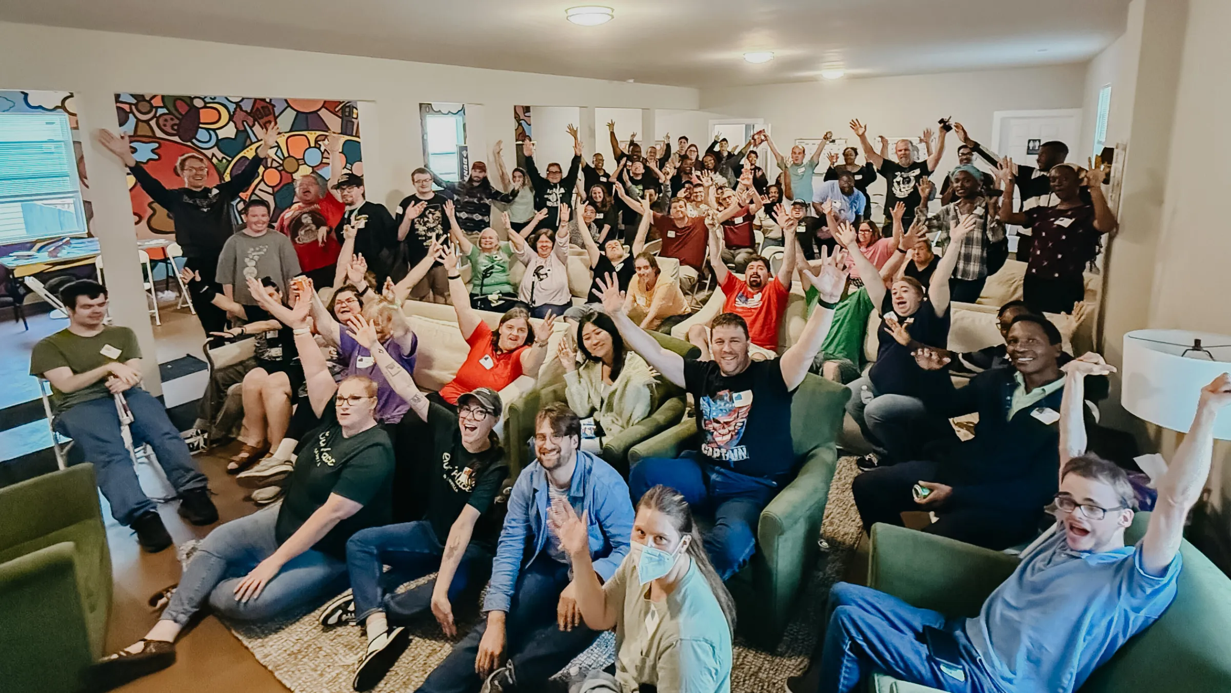 A large group photo at an event at Our Place where adults with intellectual and developmental disabilities (IDD) live alongside graduate students and young adults seeking affordable housing