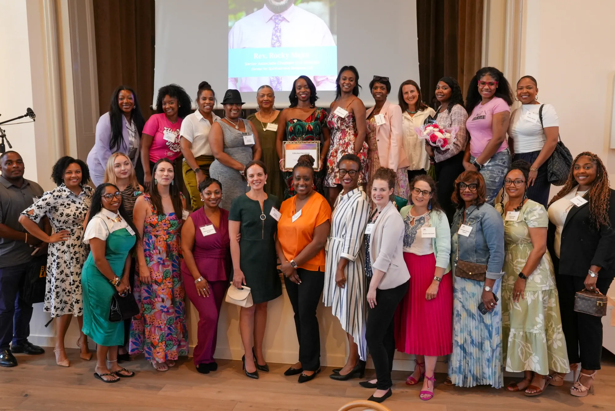 Edwina Freema celebrates her award with members of DYMON and the community